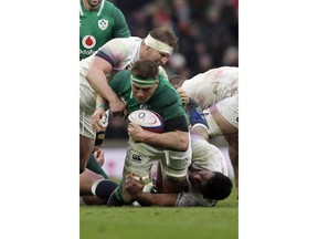 Ireland's CJ Stander is brought down by England's Dylan Hartley, top, and Mako Vunipola, on ground, during the Six Nations rugby union match between England and Ireland at Twickenham stadium in London, Saturday, March 17, 2018.