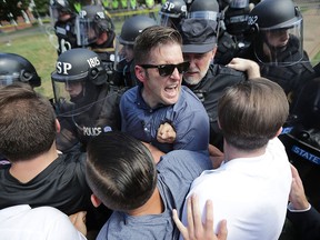 White nationalist Richard Spencer, who was mentored by alt-right "godfather" Paul Gottfried, clashes with police after a "Unite the Right" rally was declared an unlawful gathering on Aug. 12, 2017, in Charlottesville, Va.
