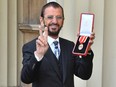Ringo Starr poses with his medal after being appointed Knight Commander of the Order of the British Empire at an investiture ceremony at Buckingham Palace in London on March 20, 2018.