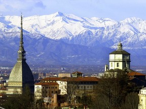FILE - In this Feb. 20, 2006 file photo, the Mole Antoneliana, left, Turin's most famous landmark, is backdropped by the Alps, in Turin, northern Italy. The Italian Olympic Committee sent a letter of intent to the IOC on Thursday, March 29, 2018, stating its plans of combining Milan and Turin to bid for the 2026 Winter Olympics.