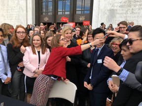 Oregon Gov. Kate Brown hands out one of the pens that she used to sign the first gun-control legislation signed into law in America since the Valentine's Day massacre at a Florida high school, on the steps of the state Capitol in Salem, Ore., Monday, March 5, 2018. Oregon high school students were among those who observed the signing.