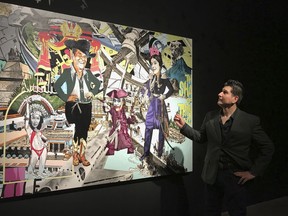 In this Feb. 16, 2018, photo border artist Claudio Dicochea explains one of the paintings in his "Acid Baroque" exhibit on display at the Scottsdale Museum of Contemporary Art in Scottsdale, Ariz., through May 20. These and other works by the 45-year-old Dicochea give a contemporary psychedelic spin to the colonial "casta" or caste paintings first created in 18th century Mexico, taking us to the crossroads of colonialism and modern day popular culture as he examines the concept of "mestizaje," or mixed identity.