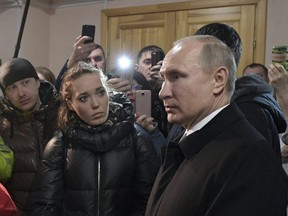 Russian President Vladimir Putin listens to locals and relatives of the victims of a fire in a multi-story shopping centre in the Siberian city of Kemerovo, about 3,000 kilometres east of Moscow, Russia, Tuesday, March 27, 2018.
