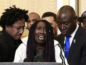 Sequita Thompson, center, discusses the shooting of her grandson, Stephon Clark, during a news conference, Monday, March 26, 2018, in Sacramento, Calif. Clark, who was unarmed, was shot and killed by Sacramento police officers last week who were responding to a call about a person smashing car windows. Thompson was accompanied by Clark's brother Ste'vonte Clark, left, and attorney Ben Crump, right.