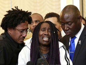 CORRECTS TO SAY THOMPSON WAS ACCOMPANIED BY CLARK'S UNCLE KURTIS GORDON AT LEFT - A tearful Sequita Thompson, center, discusses the shooting of her grandson, Stephon Clark, during a news conference, Monday, March 26, 2018, in Sacramento, Calif. Clark, who was unarmed, was shot and killed by Sacramento police officers  who were responding to a call about person smashing car windows a week ago. Thompson was accompanied by Clark's uncle, Kurtis Gordon, left, and attorney Ben Crump, right.