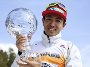 Japan's  Akito Watabe celebrates with the trophy for the overall Nordic Combined World Cup winner in schonach, Germany, Sunday, March 25, 2018.