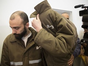 French consulate worker Romain Franck, a French employee of France's Consulate in Jerusalem, covers his face during a hearing at the district court in in the southern Israeli city of Beersheba, Monday, March 19, 2018. Franck has been arrested on charges of smuggling dozens of guns from the Gaza Strip to the West Bank. Israel's internal security agency said Franck smuggled more than 70 guns on five occasions in his consular vehicle, which was subjected to more lenient security checks than other vehicles.