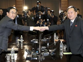 South Korean Unification Minister Cho Myoung-gyon, left, poses with North Korean delegation head Ri Son Gwon for photographers before their meeting at the northern side of the Panmunjom, North Korea, Thursday, March 29, 2018. High-level officials from North and South Korea began talks at a border village Thursday to prepare for an April summit between their leaders amid a global diplomatic push to resolve the standoff over the North's nuclear program. (Korea Pool via AP)