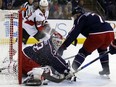 Blue Jackets goalie Sergei Bobrovsky stops a shot in front Ottawa Senators defenceman Erik Karlsson, left, as the Jackets' Jack Johnson defends during the first period of their game in Columbus, Ohio, on Saturday night.
