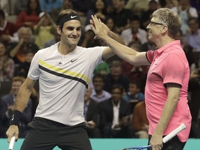 Roger Federer, of Switzerland, left, celebrates with partner Bill Gates as they play an exhibition tennis match against Jack Sock and Savannah Guthrie in San Jose, Calif., Monday, March 5, 2018.