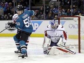 Washington Capitals goaltender Philipp Grubauer, right, stops a shot behind San Jose Sharks' Chris Tierney (50) during the first period of an NHL hockey game Saturday, March 10, 2018, in San Jose, Calif.