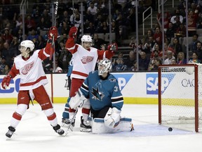 San Jose Sharks goaltender Martin Jones, center right, gives up a goal to Detroit Red Wings' Trevor Daley (not shown) as Red Wings' Tyler Bertuzzi, left, and Gustav Nyquist, center left, celebrate during the first period of an NHL hockey game Monday, March 12, 2018, in San Jose, Calif.