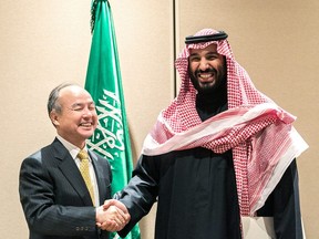 Masayoshi Son, chairman and chief executive officer of SoftBank Group Corp., left, shakes hands with Mohammed bin Salman, Saudi Arabia's crown prince, after signing an agreement in New York, U.S., on Tuesday, March 27, 2018.