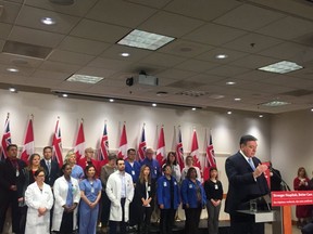 Ontario Finance Minister Charles Sousa (far-right)  with health-care professionals at a hospital funding announcement in Toronto on March 22, 2018.  Sousa later apologized for calling female and male hospital workers 'eye candy.'