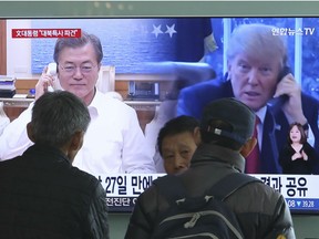 People watch a TV screen showing U.S. President Donald Trump and South Korean President Moon Jae-in, left, at the Seoul Railway Station in Seoul, South Korea, Friday, March 2, 2018. Moon plans to send a special envoy to North Korea soon to set up more meaningful dialogue between the rivals that Seoul hopes will eventually include discussions over disarming the North of nuclear weapons. The signs at left top read: " President Moon sends a special envoy to North Korea ."