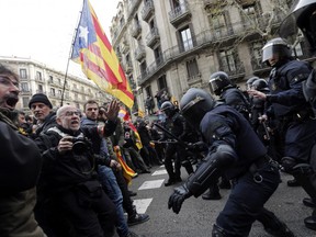 Catalan Mossos d'Esquadra regional police officers clash with pro-independence supporters trying to reach the Spanish government office in Barcelona, Spain, Sunday, March 25, 2018.