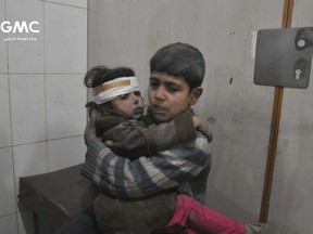 FILE - This file photo released Feb. 21, 2018 provided by the Syrian anti-government activist group Ghouta Media Center, shows two Syrian children who were wounded during airstrikes and shelling by Syrian government forces, at a makeshift hospital, in Ghouta, a suburb of Damascus, Syria. After seven years of war in Syria, the United Nations has one thing to say: Stop the war on children. Of Syria's estimated 10 million children, 8.6 million are now in dire need of assistance. While the U.N. has verified about 2,500 children killed between 2014 and 2017, it says the actual numbers are much higher. (Ghouta Media Center via AP, File)