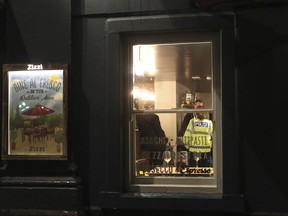 Police inside a restaurant in Salisbury, England Monday March 5, 2018 that was closed in connection with the incident in which Sergei Skripal was found critically ill by exposure to an unknown substance. Skripal, a former Russian spy is in critical condition after coming into contact with an "unknown substance." Authorities did not identify the man, but the Press Association and other British media identified him Monday, March 5, as Sergei Skripal who was convicted in 2006 on charges of spying for Britain and sentenced to 13 years but was freed in 2010 in a U.S.-Russian spy swap.