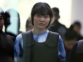 FILE - In this Oct. 12, 2017, file photo, Vietnamese Doan Thi Huong is escorted by police officers as she arrives for a court hearing at Shah Alam court house in Shah Alam, outside Kuala Lumpur, Malaysia. Huong, accused of killing Kim Jong Nam, the North Korean leader's estranged half brother told police she realized she had been used to murder him after she was detained, her lawyer said Tuesday, March 20, 2018.