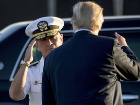 FILE - In this Nov. 3, 2017, file photo, Command Commander Adm. Harry Harris, left, salutes President Donald Trump as he boards Air Force One at Joint Base Pearl Harbor Hickam, Hawaii,  to travel to Yokota Air Base in Fussa, Japan. The commander of U.S. forces in the Pacific warned that the removal of term limits to allow Chinese President Xi Jinping to remain in office indefinitely could be a harbinger of Beijing's direction and the strategic threat it poses to America.