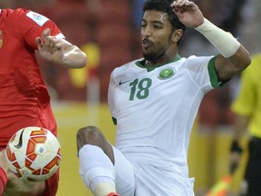 FILE - In this Jan. 10, 2015, file photo, Saudi Arabia's Salem Al-Dawsari battles for the ball during a first round soccer match against China at the AFC Asia Cup in Brisbane, Australia. After years of Saudi Arabian players staying home, nine were sent to clubs in the top two tiers of Spanish football in January until the end of the current season. Three of those, Al-Dawsari, Fahad Al Muwallad and Yahya Shehri, are established internationals and have been named in the latest roster to take on Ukraine and Belgium in World Cup warm-ups on Friday, March 23, 2018 and next Tuesday, March 27.