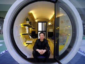 In this Tuesday, March 13, 2018, photo, architect James Law poses during an interview at his OPod tube house in Hong Kong's industrial area of Kwun Tong. Hong Kong's notoriously expensive housing makes owning an affordable home a pipe dream for many residents. But the local architect proposed a novel idea to help alleviate the problem: building stylish micro-apartments inside giant concrete drainage pipes.