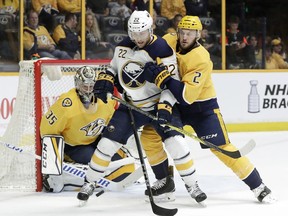 Nashville Predators defenseman Anthony Bitetto (2) pushes Buffalo Sabres center Johan Larsson (22), of Sweden, as goalie Pekka Rinne (35), of Finland, watches a shot in the first period of an NHL hockey game Saturday, March 31, 2018, in Nashville, Tenn.
