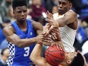 Kentucky's Hamidou Diallo (3) reaches for a rebound with Tennessee's Admiral Schofield, top right, and Grant Williams, bottom right, during the first half of an NCAA college basketball championship game at the Southeastern Conference tournament Sunday, March 11, 2018, in St. Louis.