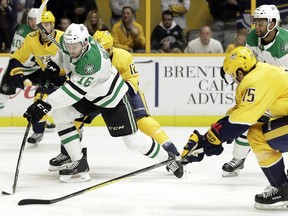 Dallas Stars center Jason Dickinson (16) moves the puck past Nashville Predators right wing Craig Smith (15) in the first period of an NHL hockey game Tuesday, March 6, 2018, in Nashville, Tenn.