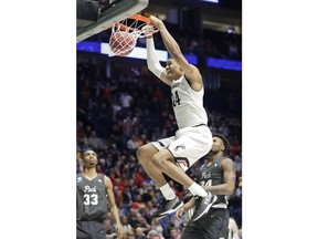 Cincinnati forward Kyle Washington (24), dunks the ball over Nevada guards Jordan Caroline (24) and Josh Hall (33), during the first half of a second-round game in the NCAA college basketball tournament in Nashville, Tenn., Sunday, March 18, 2018.