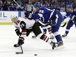 Tampa Bay Lightning defenseman Mikhail Sergachev (98) takes down Arizona Coyotes center Nick Cousins (25) during the first period of an NHL hockey game Monday, March 26, 2018, in Tampa, Fla.