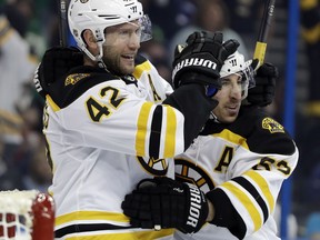 Boston Bruins right wing David Backes (42) celebrates his goal against the Tampa Bay Lightning with Brad Marchand (63) during the first period of an NHL hockey game Saturday, March 17, 2018, in Tampa, Fla.