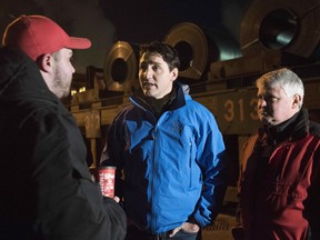 Prime Minister Justin Trudeau speaks with workers at the Essar Steel Algoma plant in Sault Ste. Marie, Ont., as MP Terry Sheehan looks on, Wednesday, March 14, 2018.