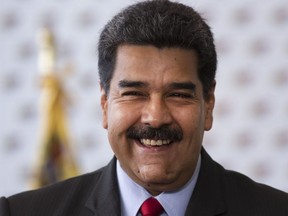 FILE - In this March 2, 2018 file photo, Venezuela's President Nicolas Maduro smiles while answering a journalist's question, at the National Electoral Council in Caracas, Venezuela. Maduro announced in a state television broadcast Thursday, March 23, that  he's tackling the country's staggering inflation by lopping three zeros off the increasingly worthless bolivar currency.