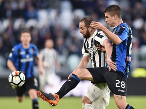 Juventus' Gonzalo Higuain, left, and Atalanta's Gianluca Mancini vie for the ball during the Italian Serie A soccer match between Juventus and Atalanta at the Allianz Stadium in Turin, Italy, Wednesday, March 14, 2018.