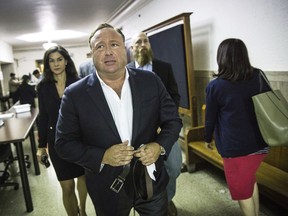 FILE - In this April 17, 2017, file photo, "Infowars" host Alex Jones arrives at the Travis County Courthouse in Austin, Texas. Brennan Gilmore, a former State Department official who became the target of harassment after posting a video showing the car attack during a white nationalist rally in Charlottesville, is suing right-wing conspiracy theorist Alex Jones and others. Gilmore's defamation lawsuit was filed Tuesday, March 13, 2018, in federal court in Charlottesville, Va.