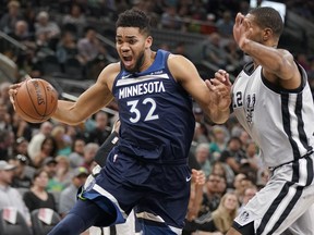 Minnesota Timberwolves' Karl-Anthony Towns (32) drives around San Antonio Spurs' LaMarcus Aldridge during the first half of an NBA basketball game, Saturday, March 17, 2018, in San Antonio.