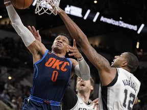 Oklahoma City Thunder's Russell Westbrook (0) shoots against San Antonio Spurs' LaMarcus Aldridge (12) and Pau Gasol during the first half of an NBA basketball game Thursday, March 29, 2018, in San Antonio.