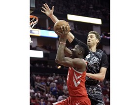 Houston Rockets' Clint Capela, left, is fouled by San Antonio Spurs' Pau Gasol during the first half of an NBA basketball game Monday, March 12, 2018, in Houston.