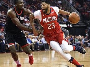 New Orleans Pelicans forward Anthony Davis (23) drives to the basket as Houston Rockets center Clint Capela, left, defends during the first half of an NBA basketball game Saturday, March 24, 2018, in Houston.