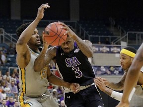 Stephen F. Austin forward Leon Gilmore III (3) drives between Southeastern Louisiana forward Moses Greenwood (13) and guard Marlain Veal (0) during the first half of an NCAA college basketball game in the Southland Conference's Men's Basketball Tournament Championship Saturday, March 10, 2018, in Houston.