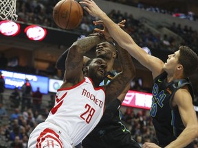 Houston Rockets forward Tarik Black (28) gets fouled by Dallas Mavericks forward Doug McDermott (20) as he goes up for a shot in the first half of an NBA basketball game Sunday, March 11, 2018 in Dallas.