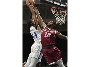 Hampton forward Charles Wilson-Fisher, left, takes a shot under pressure from North Carolina Central forward Pablo Rivas  during an NCAA college basketball game in the finals of the Mid-Eastern Athletic Conference tournament, Saturday, March 10, 2018, in Norfolk, Va.