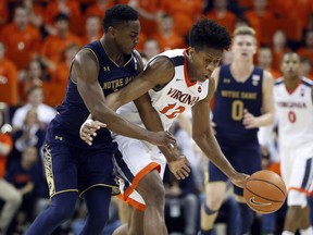 Virginia guard De'Andre Hunter (12) is fouled by Notre Dame forward Juwan Durham (11) during the second half of an NCAA college basketball game in Charlottesville, Va., Saturday, March 3, 2018. Virginia won the game 62-57.