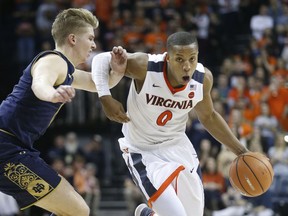 Virginia guard Devon Hall (0) drives past Notre Dame guard Rex Pflueger (0) during the second half of an NCAA college basketball game in Charlottesville, Va., Saturday, March 3, 2018. Virginia won the game 62-57.