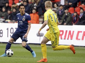 Japan's Makoto Hasebe, left, is challenged by Ukraine's Oleksandr Zinchenko during a friendly soccer match between Japan and Ukraine at Maurice Dufrasne Stadium in Liege, Belgium on Tuesday, March 27, 2018.