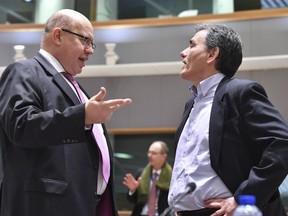 Germany's acting chief of finance Peter Altmaier, left, speaks with Greek Finance Minister Euclid Tsakalotos during a meeting of the eurogroup at the EU Council building in Brussels on Monday, March 12, 2018.