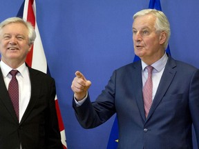 European Union chief Brexit negotiator Michel Barnier, right, gestures as he meets with British Secretary of State for Exiting the European Union David Davis at EU headquarters in Brussels on Monday, March 19, 2018.