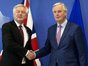 European Union chief Brexit negotiator Michel Barnier, right, shakes hands with British Secretary of State for Exiting the European Union David Davis prior to a meeting at EU headquarters in Brussels on Monday, March 19, 2018.