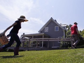 In this July 7, 2016 photograph, Elizabeth Willard Thames, left, walks back to her home, with her husband Nate, after working on their property in Vershire, Vermont. The couple, also known as "The Frugalwoods", have managed to save a majority of their income, while redefining the meaning of thrift and gaining a national following along the way.